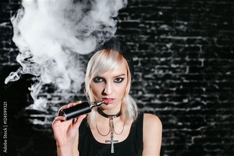 Sexy Goth Girl Smokes Electronic Cigarette On Dark Background The