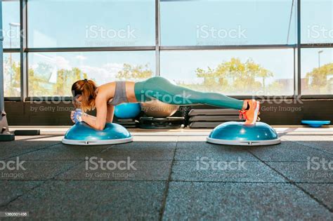 Young Female Athlete Doing Pushups On Double Bosu Ball During Workout