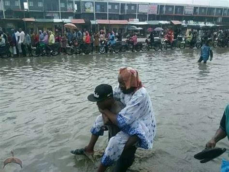 Aboki Pictured Making Money By Carrying People Across Flood In Badagry