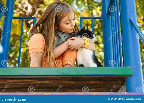 A Small And Beautiful Girl Tries To Kiss Her Favorite Cat That She