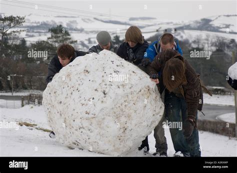 Five Young Men Rolling A Giant Snowball Up Hill Aberystwyth Wales Uk