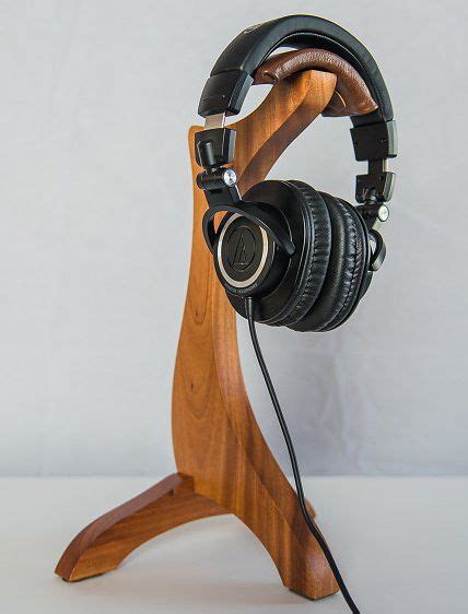 A Wooden Headphone Stand With Black Headphones On It