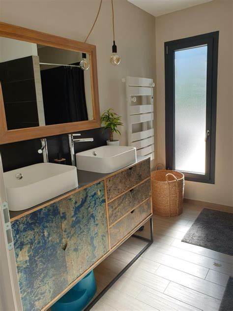 a bathroom with two sinks and a large mirror above the sink is next to a window