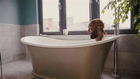 Static Shot Of Young Black Man Sitting In Bathtub Stock Video Footage
