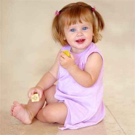 Shes Got A Great Start In Life Cute Baby Girl In A Pink Dress Playing