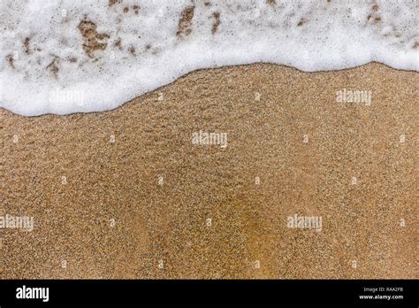 Top View Of Surface Of Clean Golden Sand At Sea Beach And White Foamy