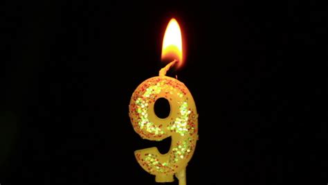 Nine Birthday Candle Flickering And Extinguishing On Black Background