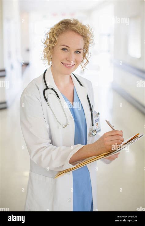 Doctor Writing On Clipboard In Hospital Corridor Stock Photo Alamy