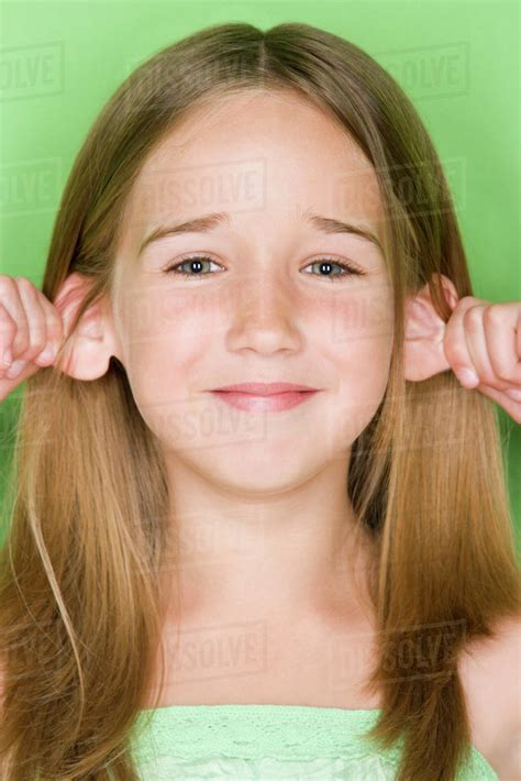 Studio Shot Portrait Of Teenage Girl Pulling Her Ears Close Up Stock