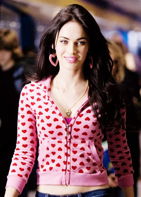 A Woman With Long Black Hair Wearing A Pink Shirt And Earrings On Her