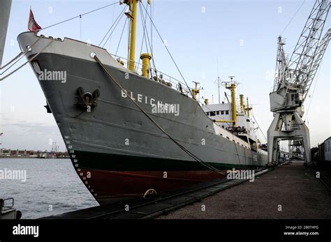 The Bleichen A German Cargo Ship Moored Beside A Row Of Dock Cranes
