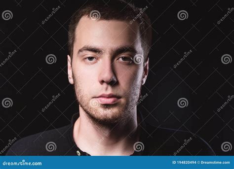 Portrait Of An Emotional Handsome Young Man On A Black Background In