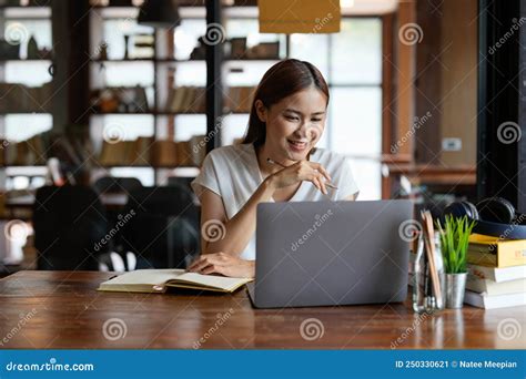 Pensive Young Asian Woman In Headphones Work On Laptop Talk Speak On Video Webcam Call Online