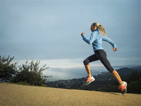 Woman Running In Mountains Stock Photo
