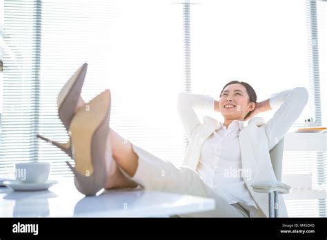 Relaxed Businesswoman Sitting With Her Feet Up Stock Photo Alamy