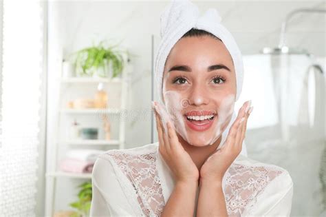 Beautiful Young Woman Applying Cleansing Foam Onto Face In Bathroom Skin Care Cosmetic Stock