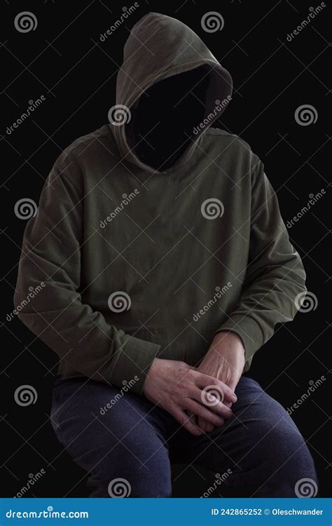 Faceless Person In Hoodie Sitting In The Darkness With Hands Crossed Mystery Man With Hood
