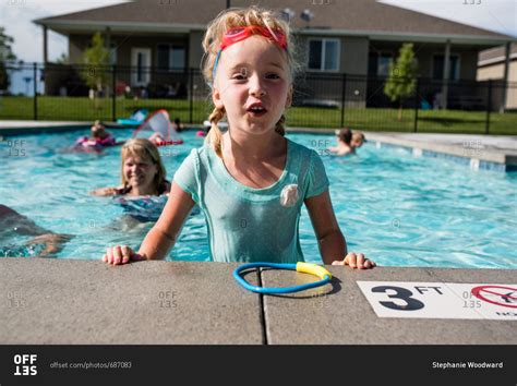 Happy Little Girl Standing In Swimming Pool On Hot Summers Day Stock
