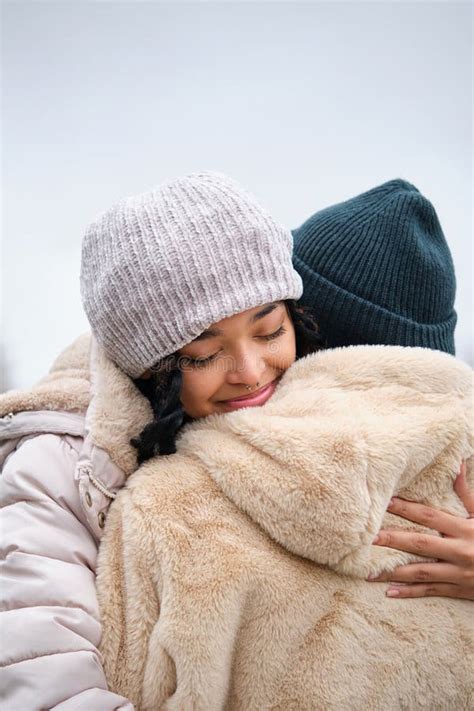 Dominican Lesbian Couple Hugging With Affection And Love At Street In Winter Stock Image