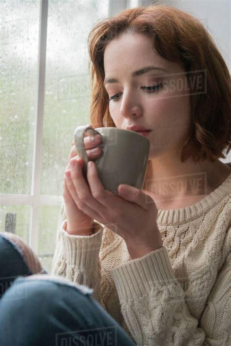 Caucasian Woman Drinking Coffee Near Rainy Window Stock Photo Dissolve
