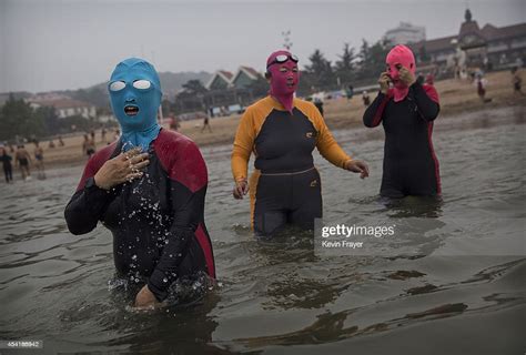 Chinese Women Wear Face Kinis As They Walk In To The Water To Swim At