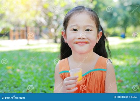 Happy Of Little Girl Drinking Orange Juice With Stained Around Her