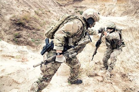 American Commando Helping Friend To Climb On Dune Stock Image Colourbox