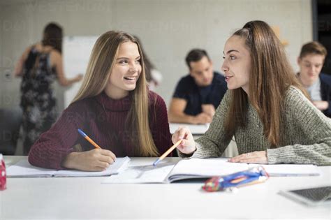 Smiling Teenage Girls Talking In Class Stock Photo
