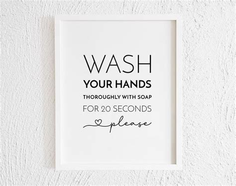 A White Framed Sign That Says Wash Your Hands Thoroughly With Soap For