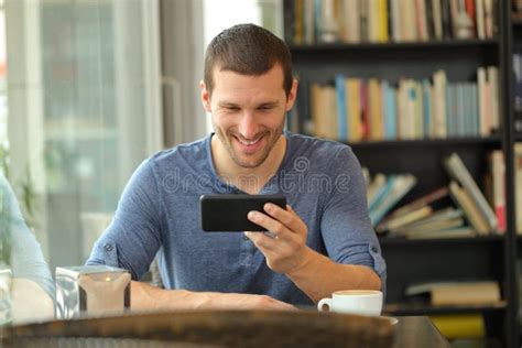 Happy Man Watching Media On Smart Phone In A Bar Stock Photo Image Of
