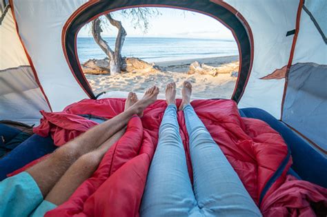 Point Of View Of Couples Feet From Inside A Tent Camping On The Beach