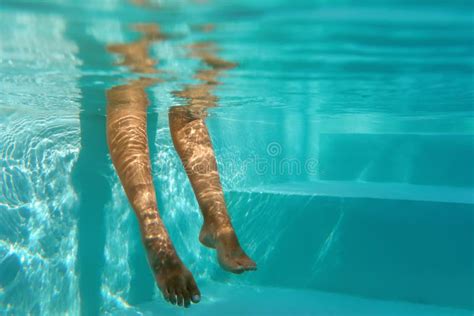 Underwater Woman Keeping Legs In Pool While Sitting On Poolside