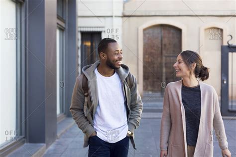 Two People Walking Down A City Street Smiling Stock Photo Offset
