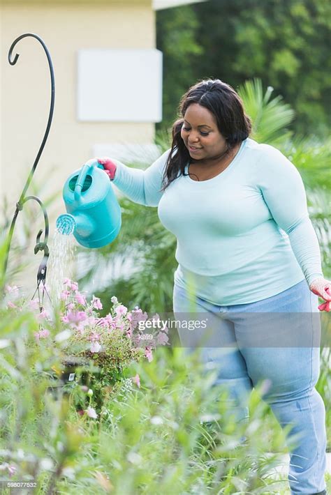 Young African American Woman Watering Plants High Res Stock Photo
