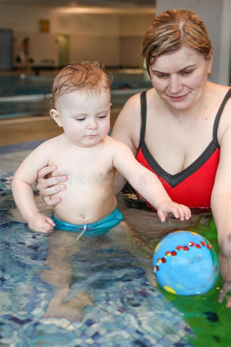 Little Baby With Blue Eyes Learning To Swim Stock Photo