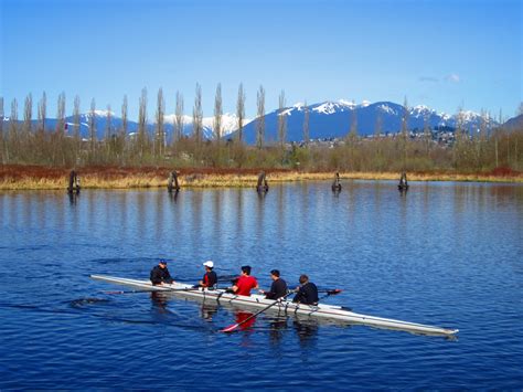 Five Person On Boat Floating On Rippling Body Of Water Over Looking