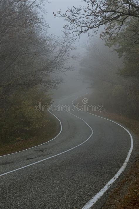 A Country Road With White Lines Of Markings Winds Around Corners In An