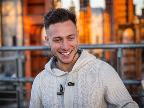 Handsome Trendy Young Man Standing On A Sidewalk In City Stock Photo