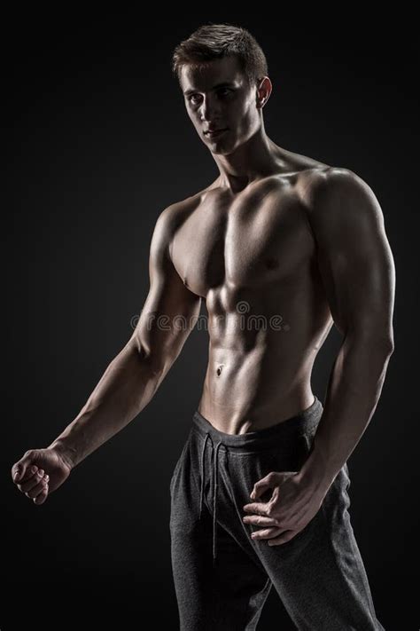 Shirtless Bodybuilder Posing Looking At Camera On Black Background
