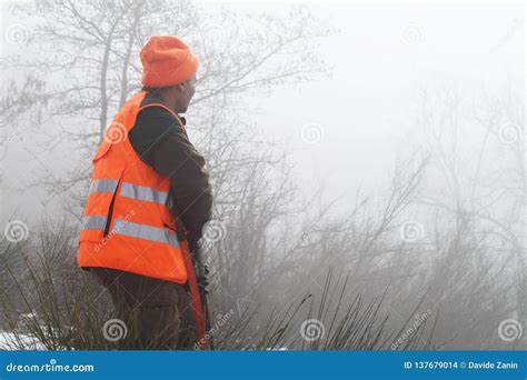 Hunter With High Visibility Clothing And Rifle Waiting For Boar