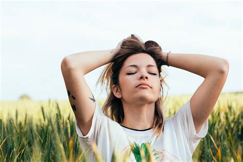 Relaxed Woman Touching Her Hair In The Field By Stocksy Contributor