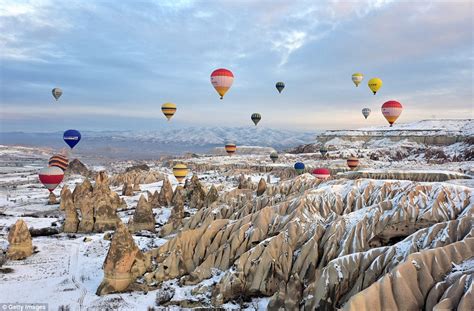 Hot Air Balloons Captured Floating Above Ancient Cappadocian Landscape