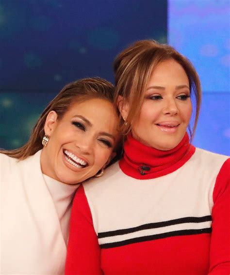 two women sitting next to each other on a tv set smiling and hugging one another