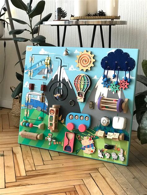 If you love the idea of exploring shapes and more with geoboards but are struggling to come up with engaging challenges, grab this free set of geoboard activity cards! Toddler busy board of bright colors 60x70 cm Activity ...