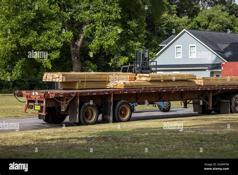 A Flatbed Truck Carrying A Load Of Construction Lumber Wood For The