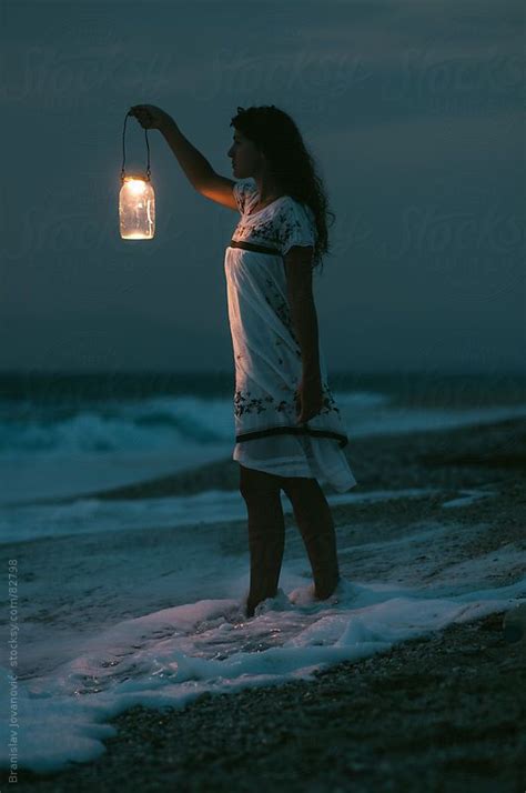 Woman With Lantern On Sea Coast By Stocksy Contributor Brkati