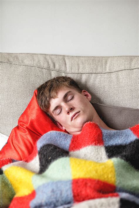 Young Man Sleeping Under A Blanket On A Couch By Stocksy Contributor Marcel Stocksy