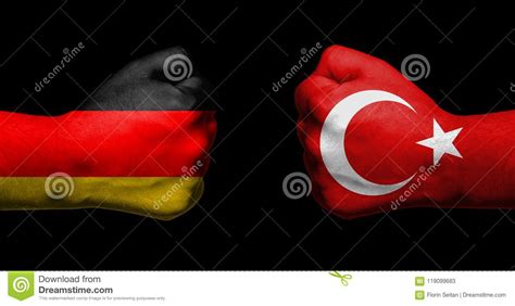 Flags Of Germany And Turkey Painted On Two Clenched Fists Facing Stock