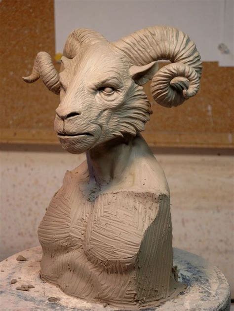 A Clay Sculpture Of A Ram With Horns On Its Head Sitting On A Table