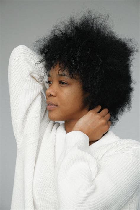 Portrait Photo Of Woman In White Sweater Posing In Front Of Gray